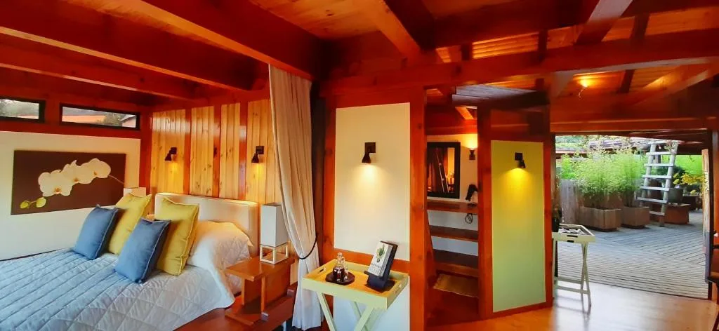 Vibrant red bedroom with queen bed, colorful pillows, and deck access