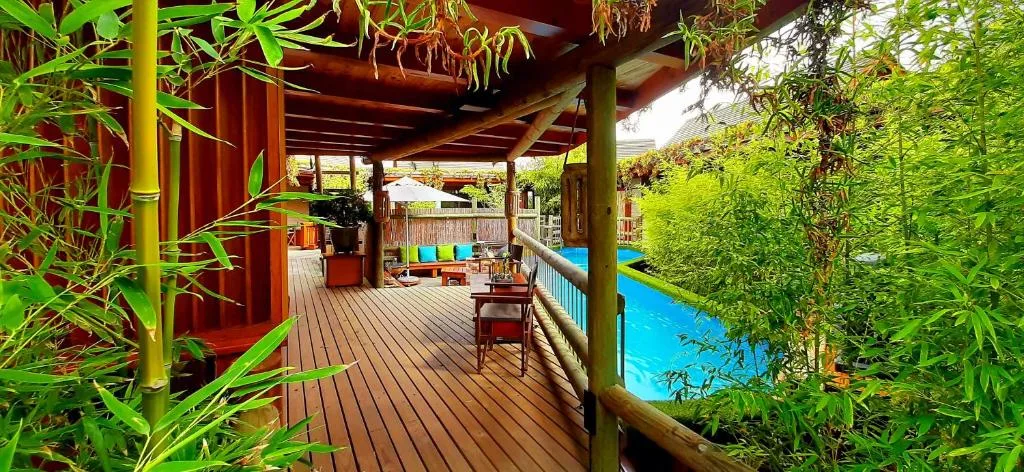 Wooden deck with pergola, bamboo plants, pool view, braai area