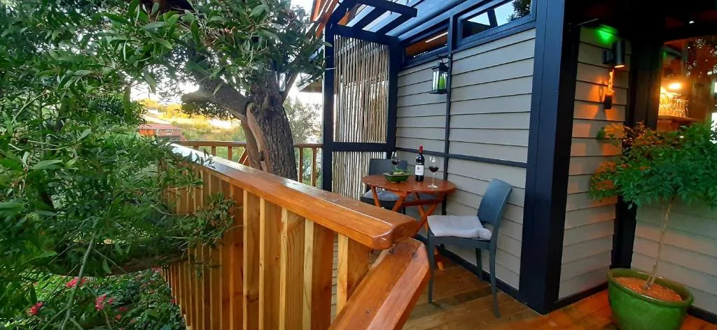 Wooden deck with seating area, pergola, and garden surroundings at dusk