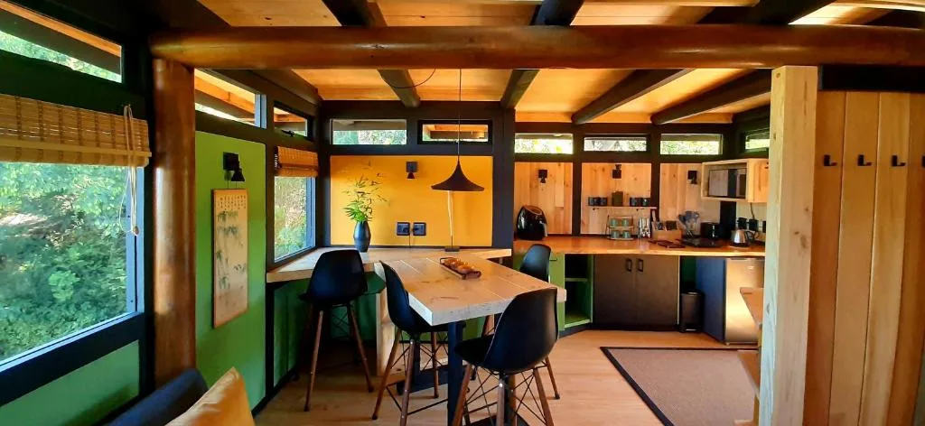 Modern dining table with black chairs in open-plan kitchen and living area