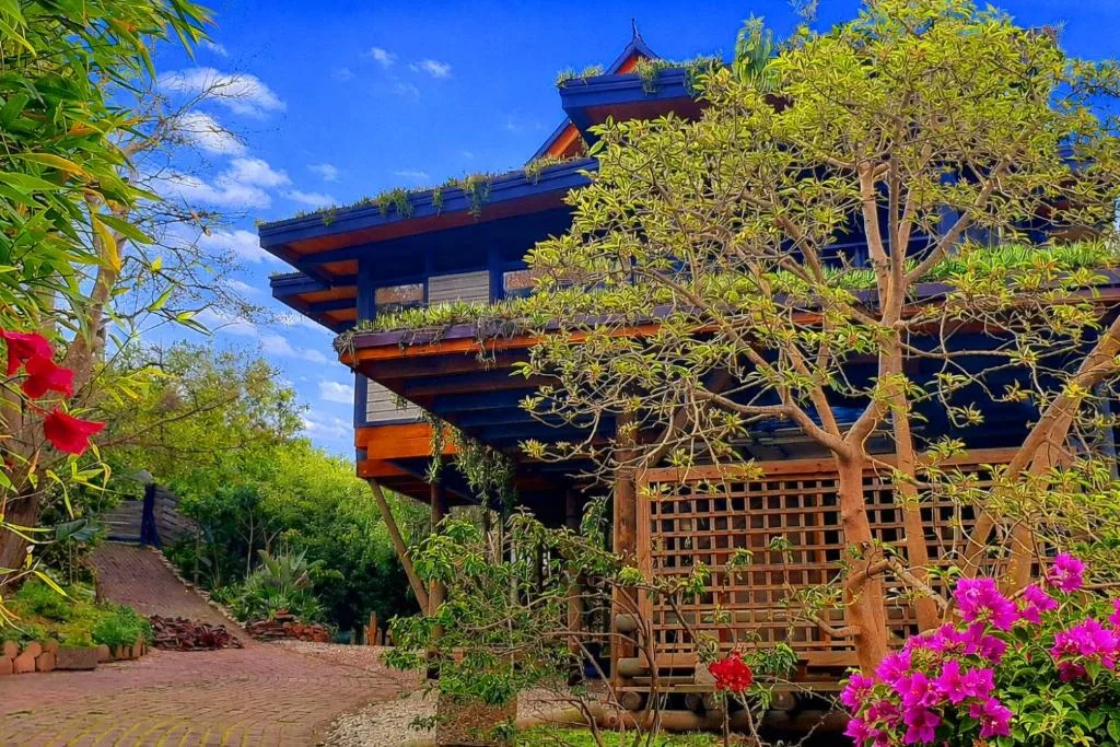 Contemporary Asian-inspired building with tiered roofs and wooden decking surrounded by blooming flowers