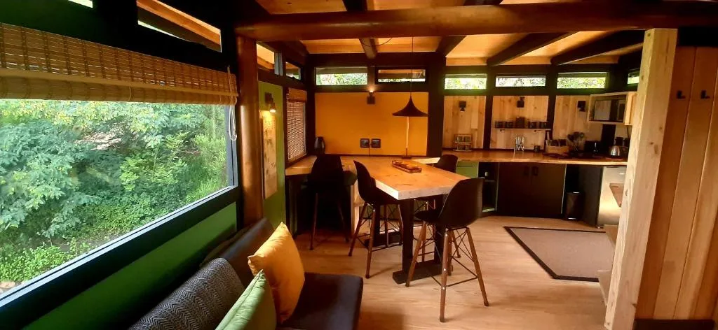 Open-plan lounge and kitchen with bar seating and garden views