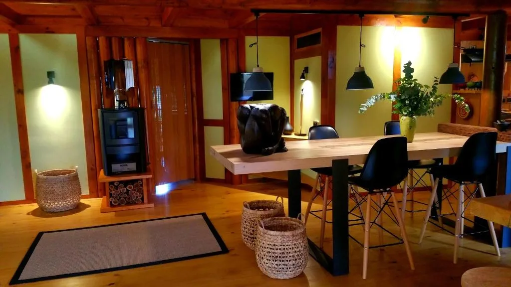 Modern open-plan lounge and dining area with wooden floors and warm lighting