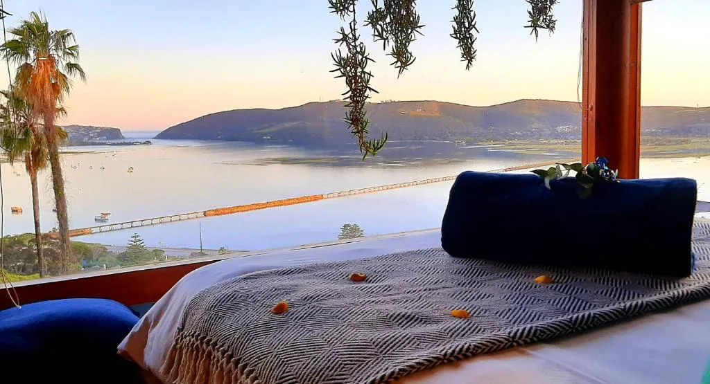 Lagoon and mountain vista visible through bedroom window at sunset