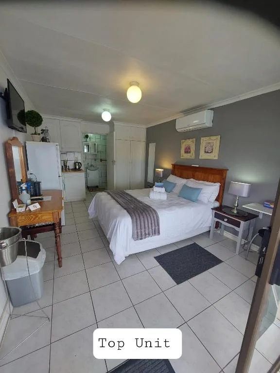 Spacious bedroom with queen bed, kitchenette, and modern amenities visible