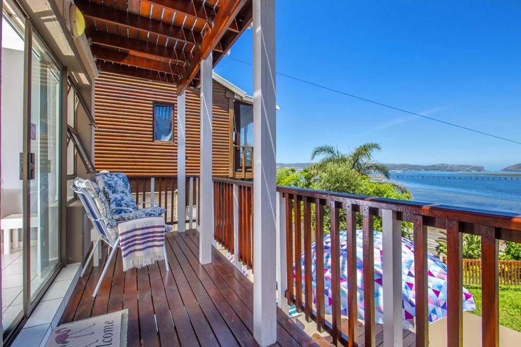Wooden deck with chair overlooking blue lagoon and mountains beyond