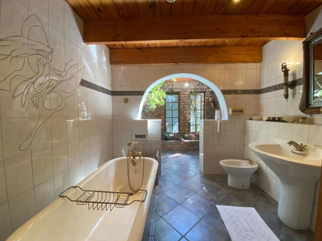 Spacious bathroom with soaking tub, double vanities, and arched doorway