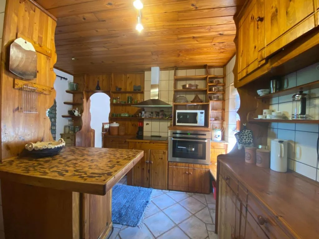 Warm wooden kitchen with counters, built-in appliances, and open shelving