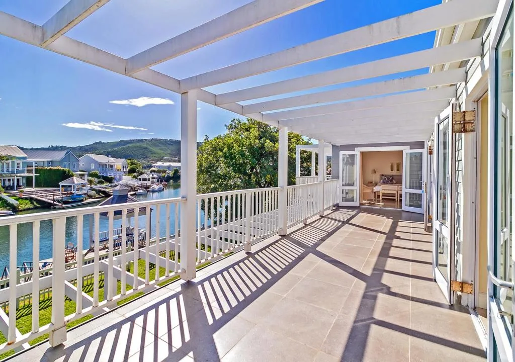 Spacious waterfront deck with pergola overlooking canal and distant mountains