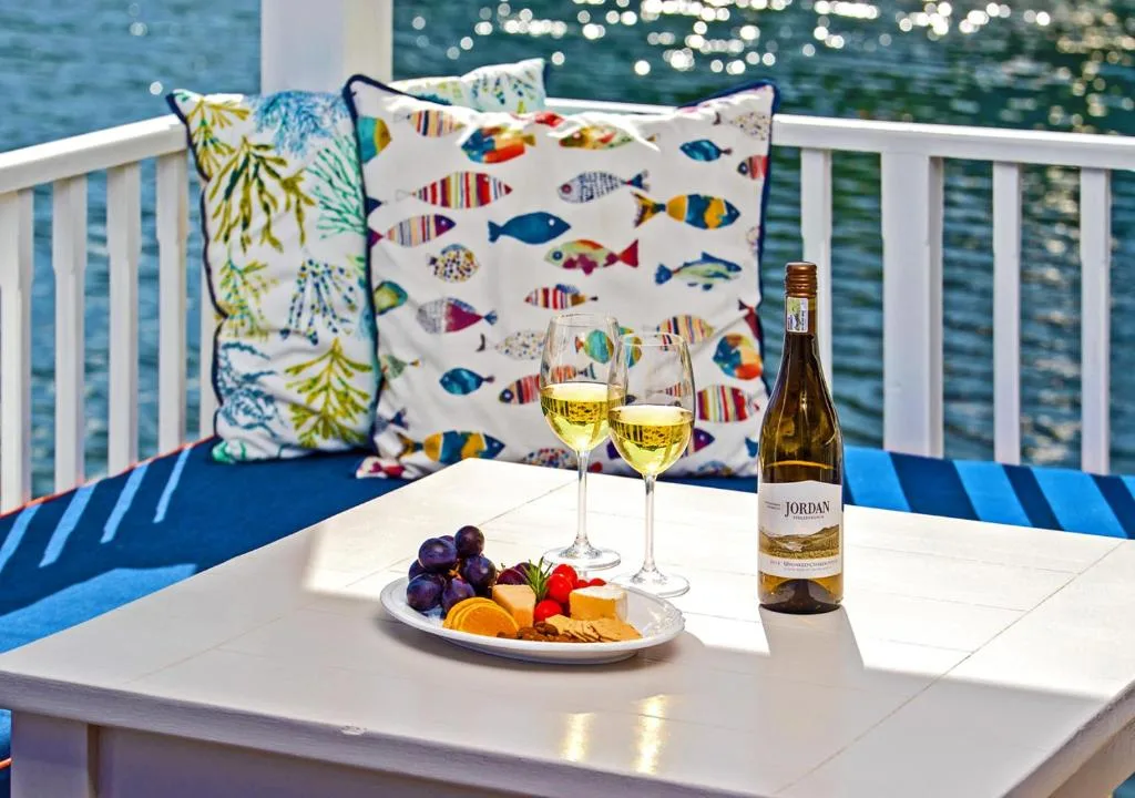 Waterfront deck with wine, fruit platter, and ocean view seating