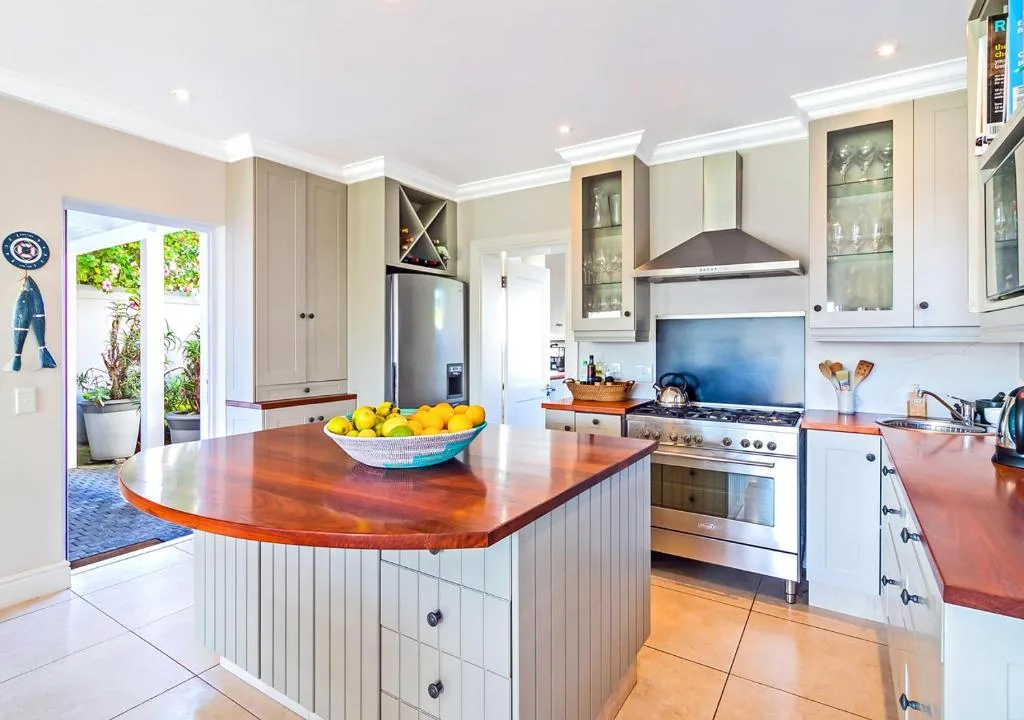 Modern kitchen with wooden island, stainless steel appliances, and garden access