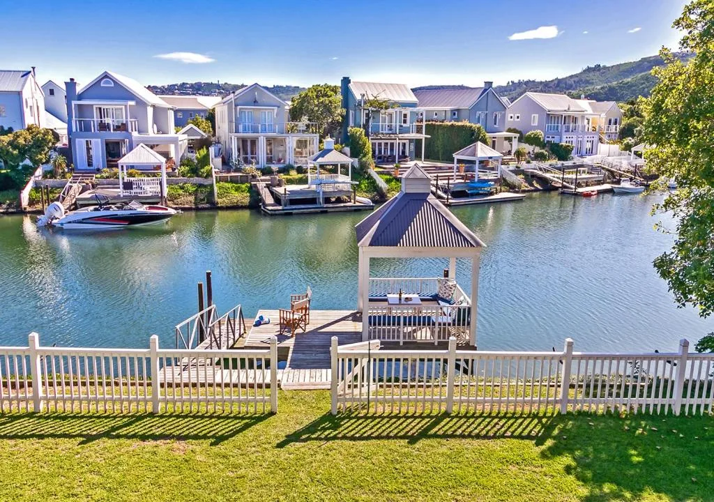 Waterfront homes with boat dock and lagoon views across canal