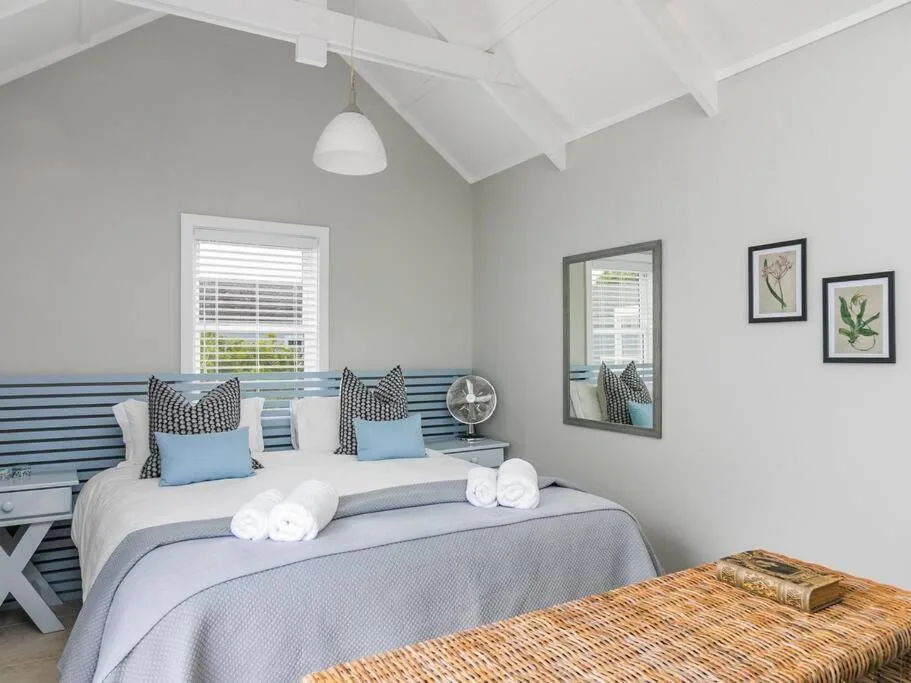 Bright bedroom with blue striped headboard and coastal décor accents