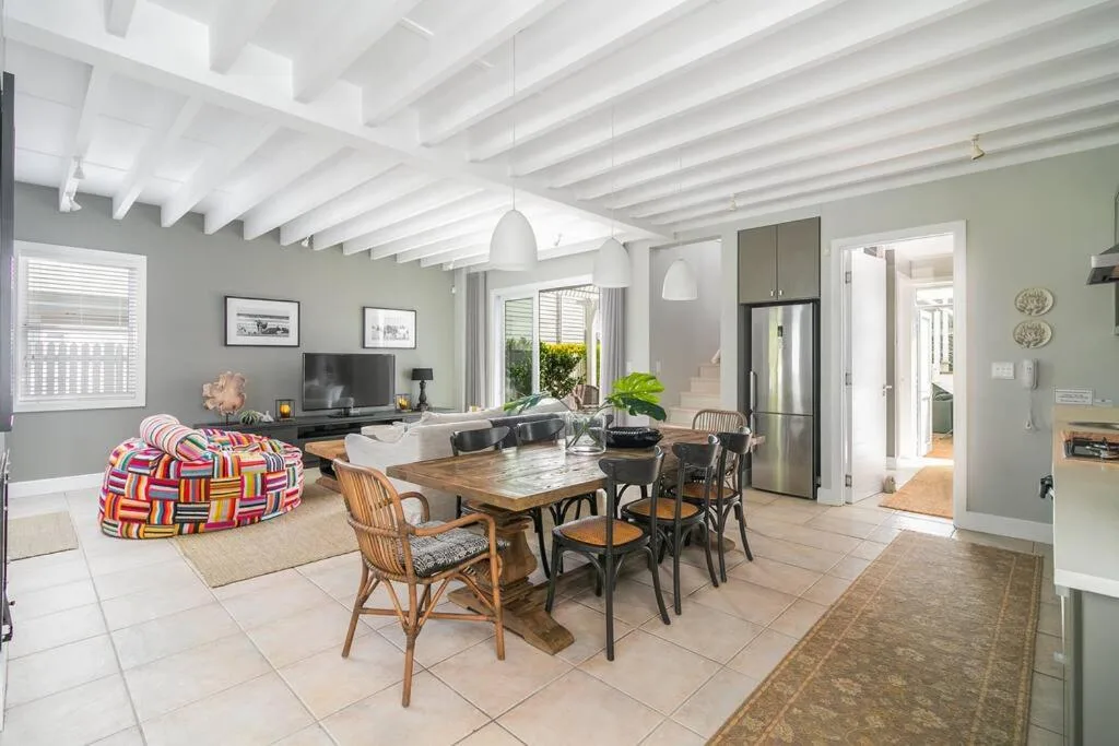 Open-plan living area with dining table, colorful bean bag, and TV entertainment setup