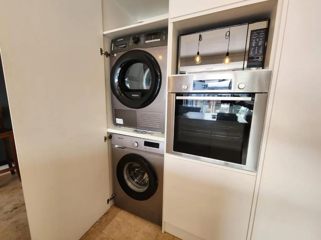 Modern laundry and kitchen appliances in compact utility space
