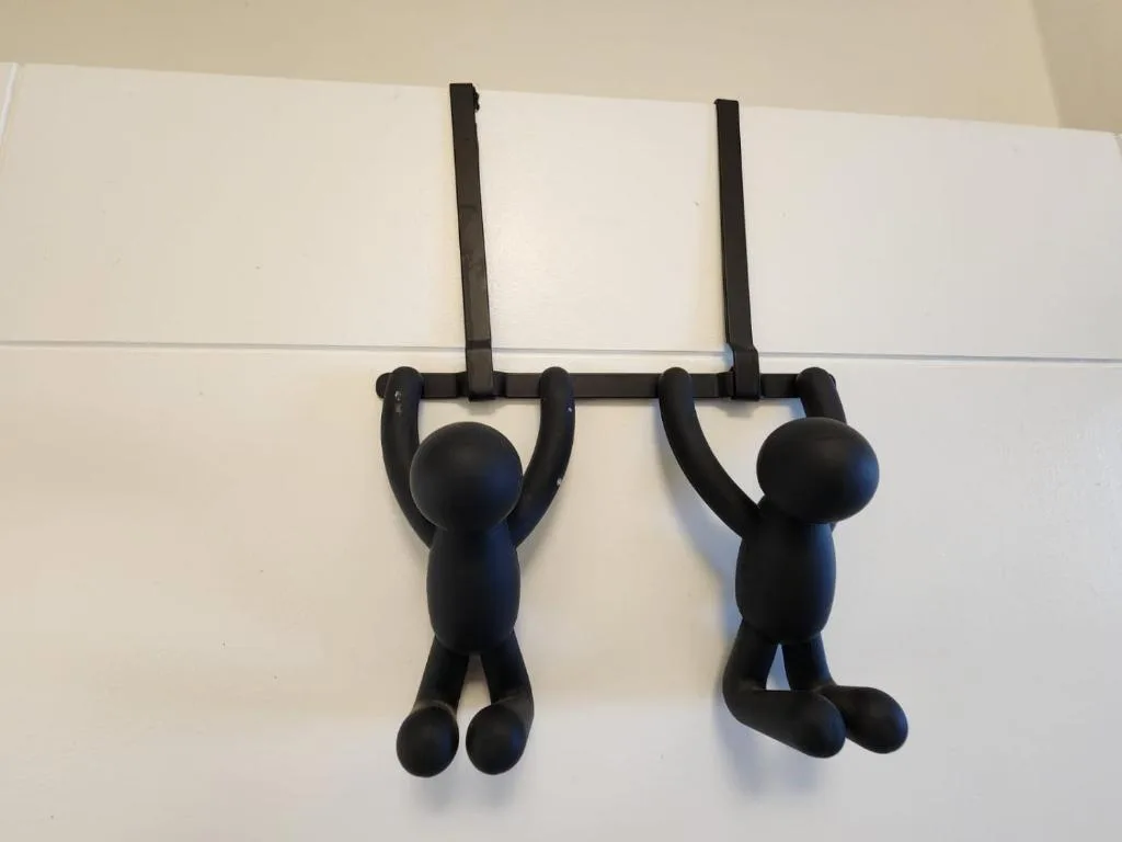 Black decorative hanging figures mounted on white wall as playful accent decor
