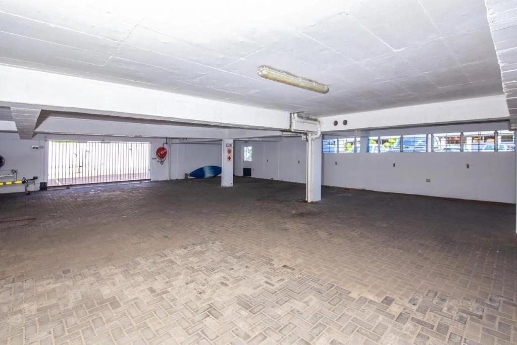 Empty garage interior with brick flooring and white support columns