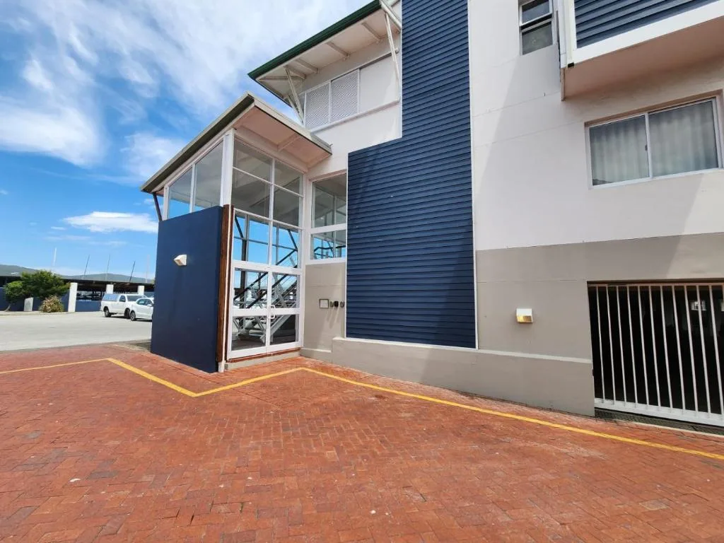 Modern apartment building entrance with brick driveway and contemporary architecture