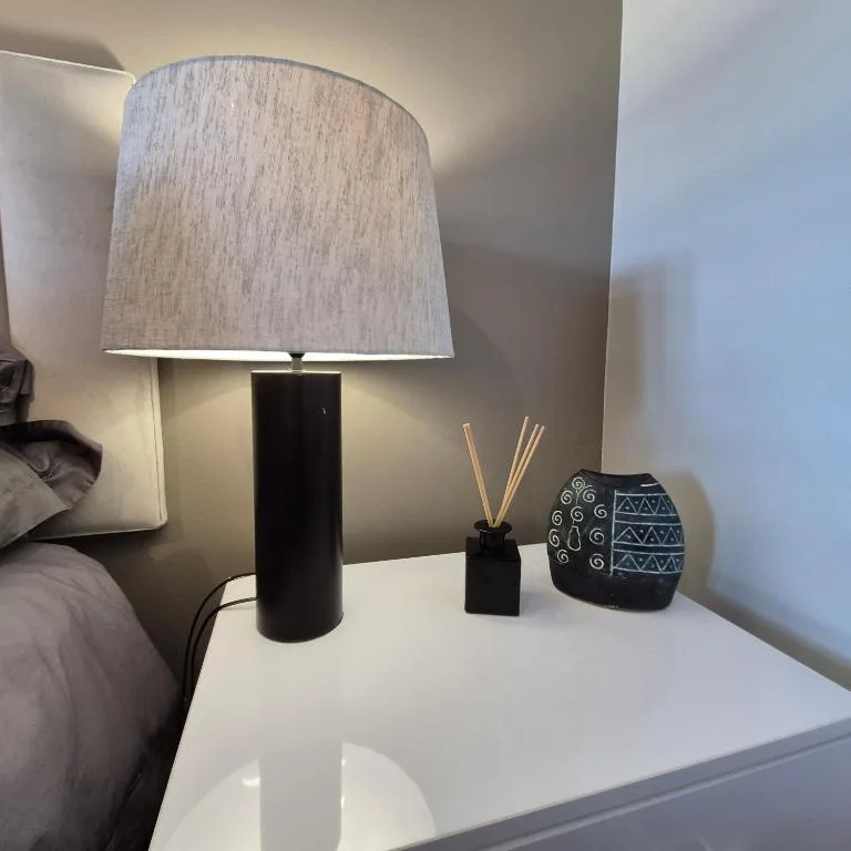 Bedside table with modern lamp, diffuser, and decorative accessories