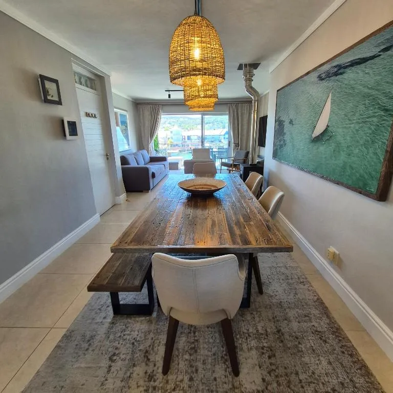 Modern dining table with cream chairs and woven pendant light fixture