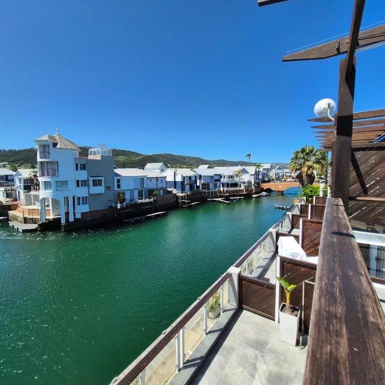 Turquoise lagoon waterfront view with colorful houses and mountains beyond
