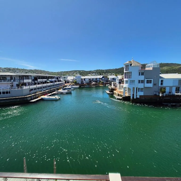 Turquoise lagoon with waterfront houses and moored boats in Knysna