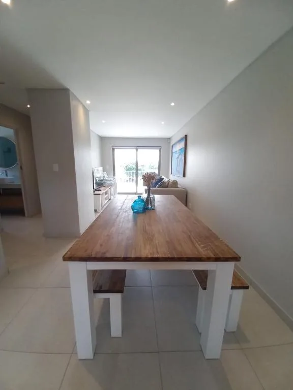 Modern dining table with wooden top and white base in bright contemporary space