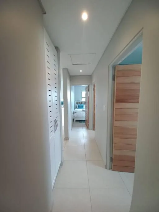 Modern hallway with wooden doors and recessed lighting throughout