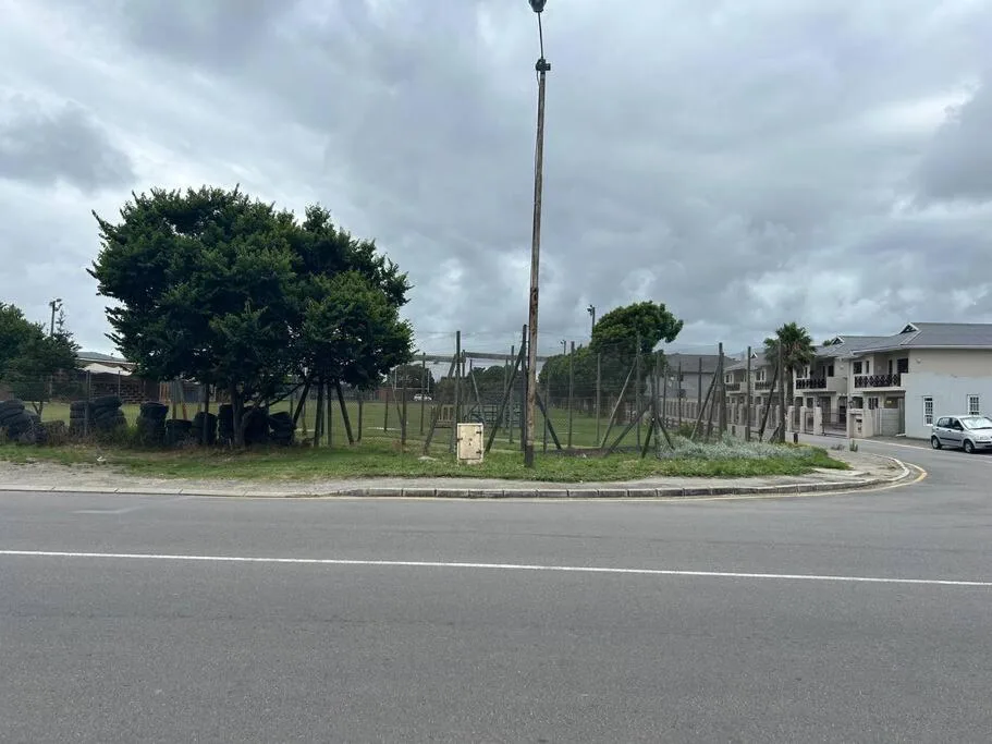 Modern apartment building entrance with manicured gardens and driveway access