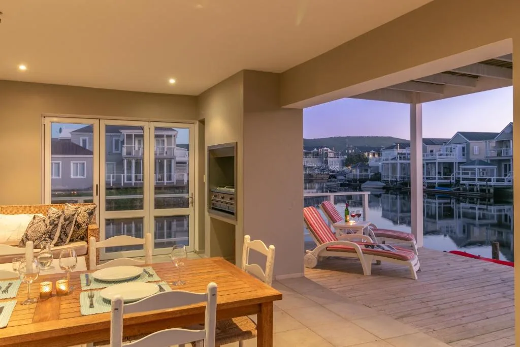 Dining table with waterfront view through open glass doors to deck