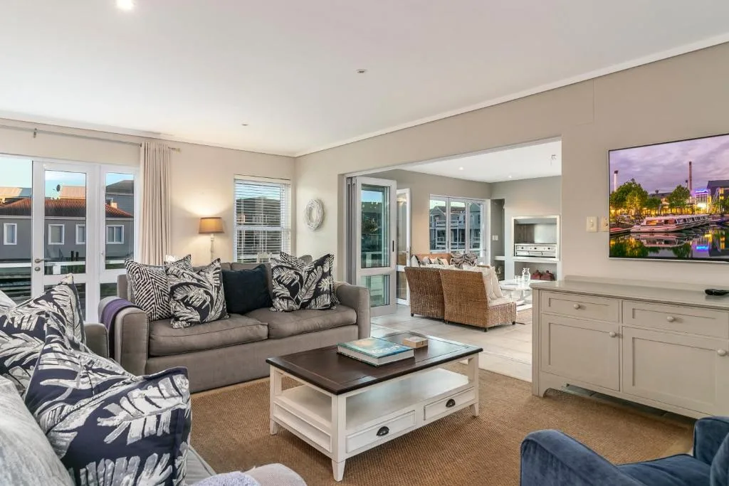 Spacious living room with gray sofa, patterned cushions, coffee table, and TV area