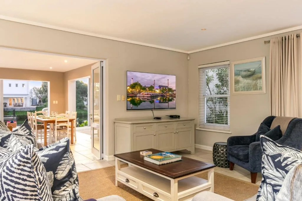 Spacious lounge with sofas, TV, and open-plan views to dining area