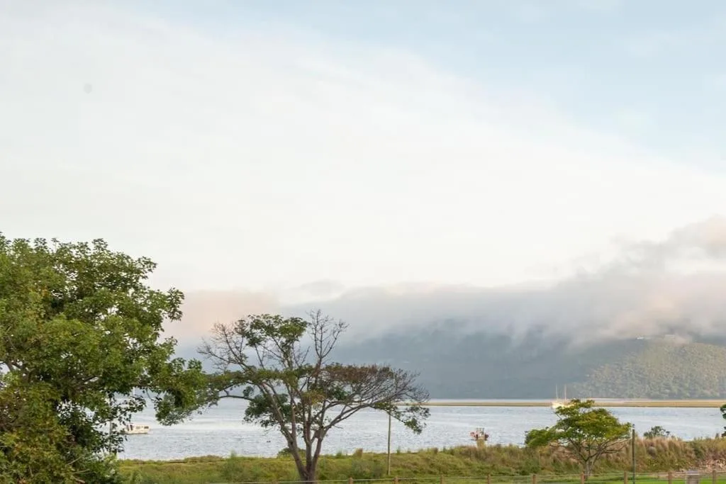 Scenic lagoon view with forested mountains and dramatic cloudy sky