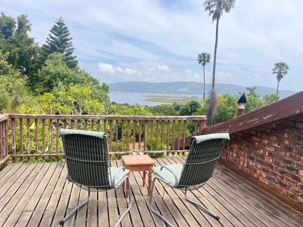 Lagoon and mountain views from wooden deck with seating chairs