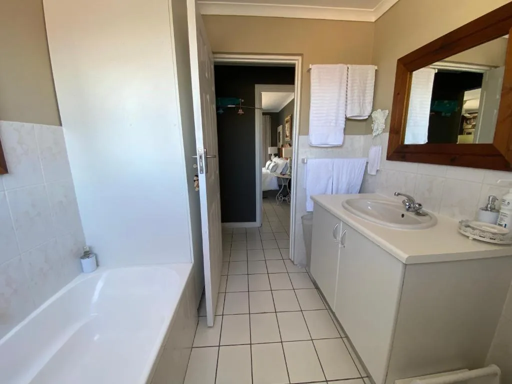 Modern bathroom with vanity sink, bathtub, and wooden-framed mirror