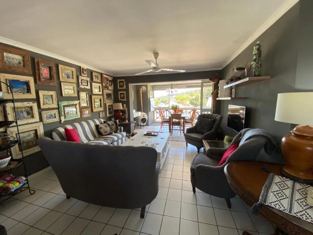 Spacious living room with black armchairs, striped sofa, gallery wall art