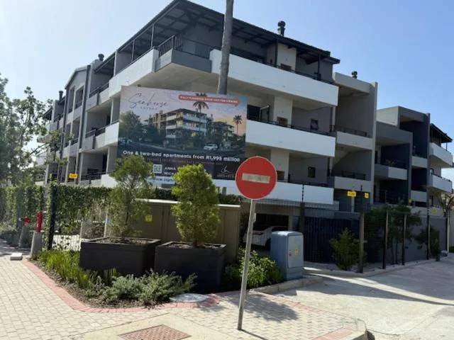 Modern multi-story apartment building with white balconies and black facade