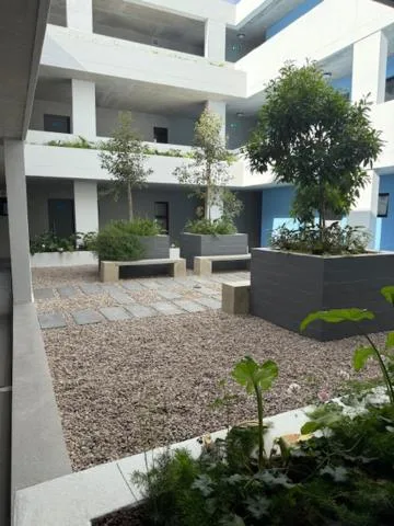 Modern white apartment building courtyard with landscaping and seating areas