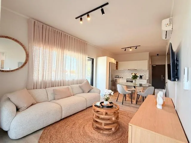 Modern living room with curved beige sofa and wooden coffee table
