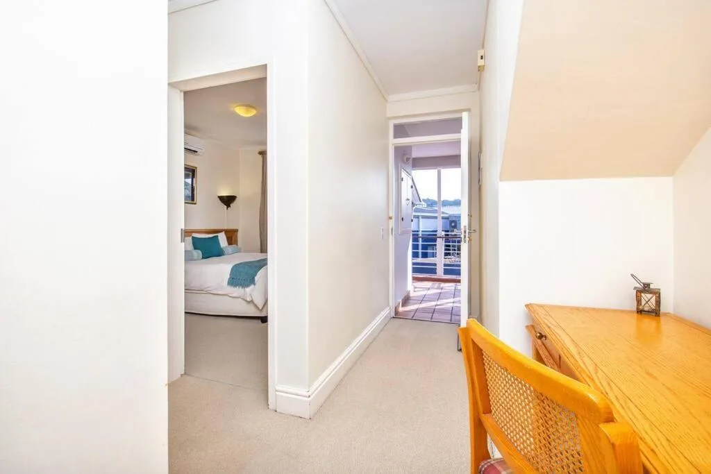 Bright bedroom with bed, open door to deck with water view