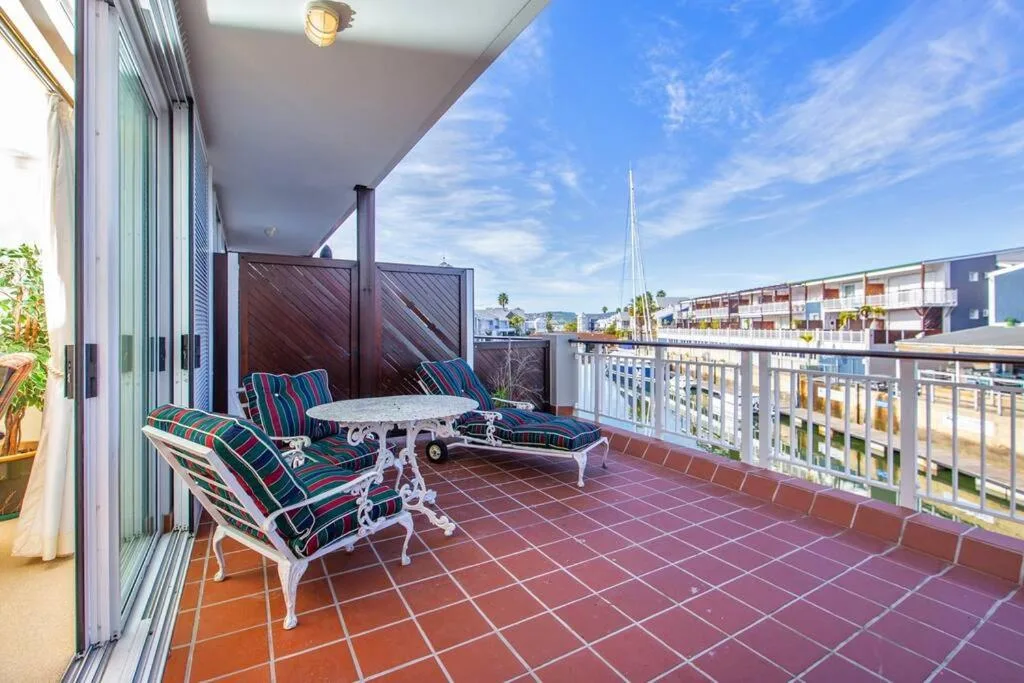 Spacious balcony with striped loungers overlooking Knysna waterfront and marina