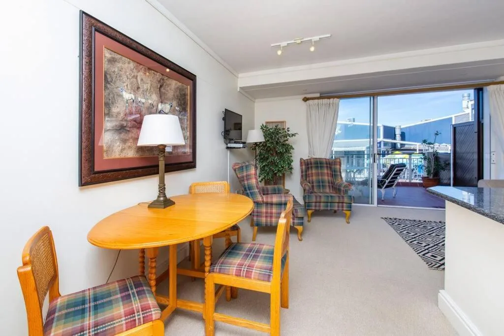 Open-plan lounge with dining table, comfortable seating, and panoramic sea views
