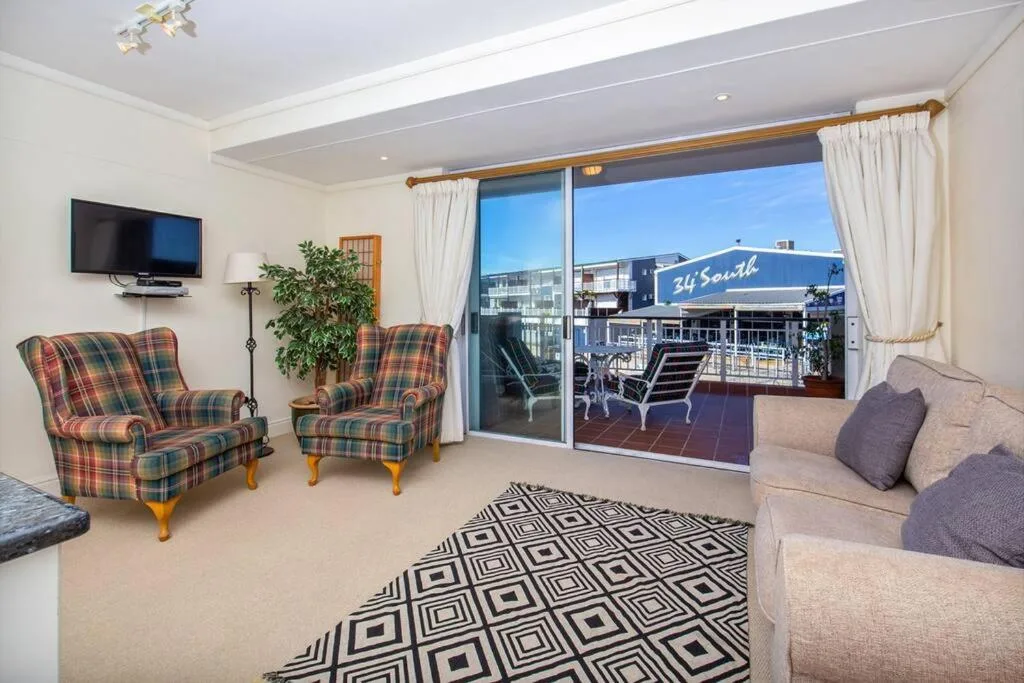 Spacious lounge with comfortable seating and panoramic waterfront views through large glass doors