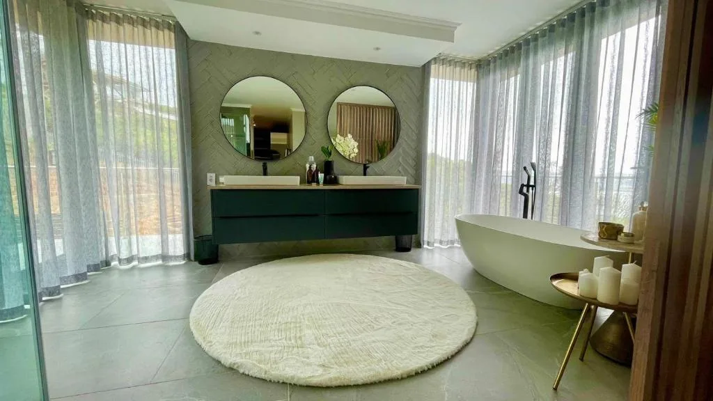 Luxurious modern bathroom with freestanding bathtub and dual vanity mirrors