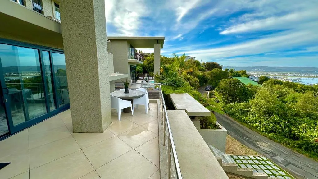Spacious patio with dining table overlooking Knysna lagoon and landscape