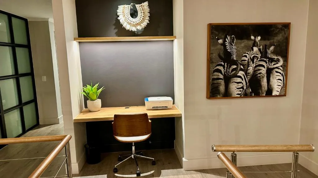 Home office nook with desk, chair, printer, and zebra artwork