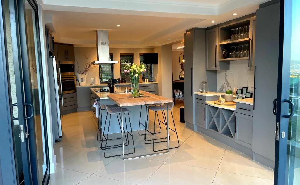 Modern kitchen with gray cabinetry, island seating, and stainless steel appliances