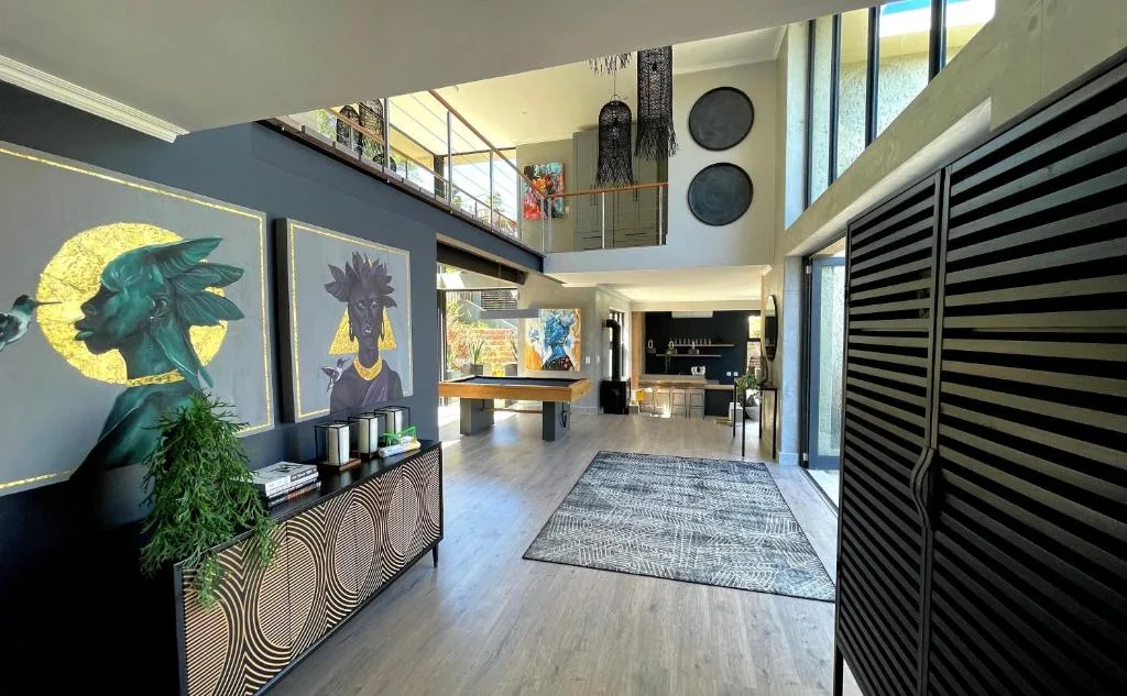 Modern open-plan lounge with bold artwork, mezzanine level, and contemporary decor