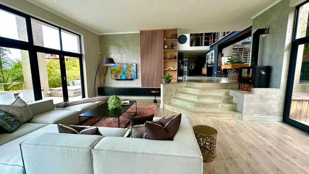 Modern living room with cream sofas, wooden floors, and garden views