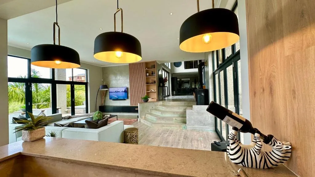Modern living room with black pendant lights and garden views through large windows